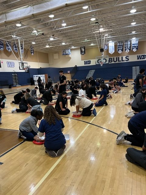 West Boca Medical Academy students assisting 9th and 11th graders in hands-only CPR.