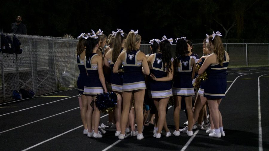 West+Boca+cheerleaders+huddled+up+at+halftime+with+their+cheerleading+coach.