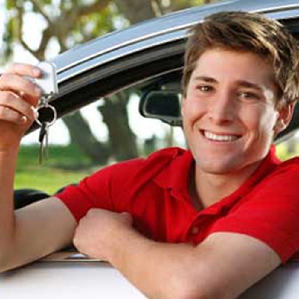 Young guy in a red shirt who appears to be about to drive. 