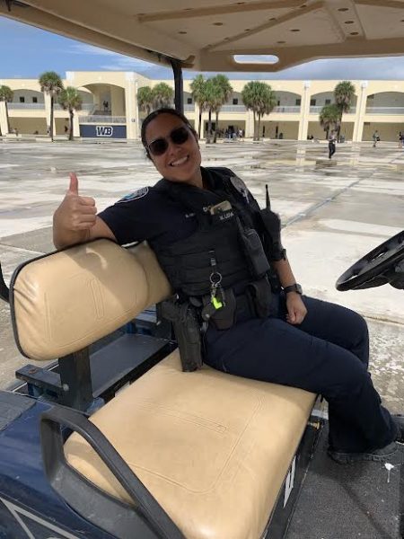 Picture of the new school police Officer, Officer Leiva on her golf cart. 