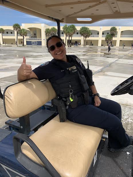 Picture of the new school police Officer, Officer Leiva on her golf cart. 