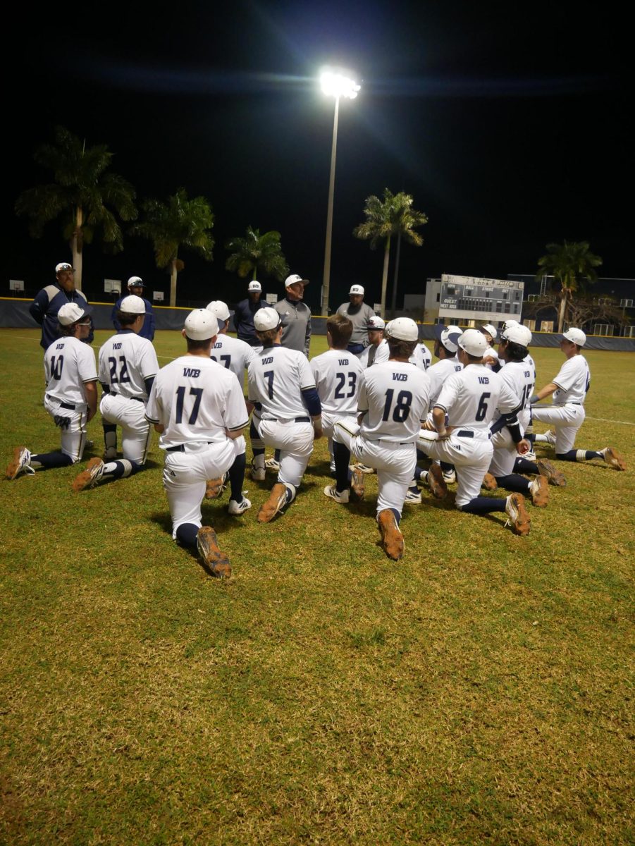The West Boca coaching staff speaking to their players postgame after the 19-2 win over Palm Beach Gardens.