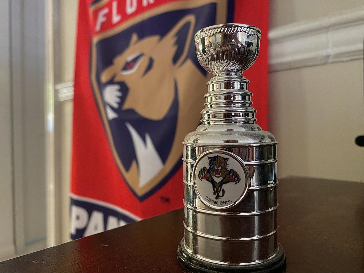 Photo of a custom made mini Stanley Cup with the Florida Panthers logo along with a Florida Panthers flag hanging.