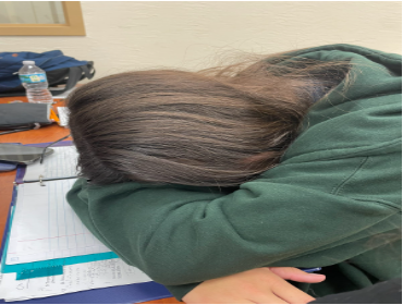 Junior student sleeping on desk, exhausted from her busy schedule