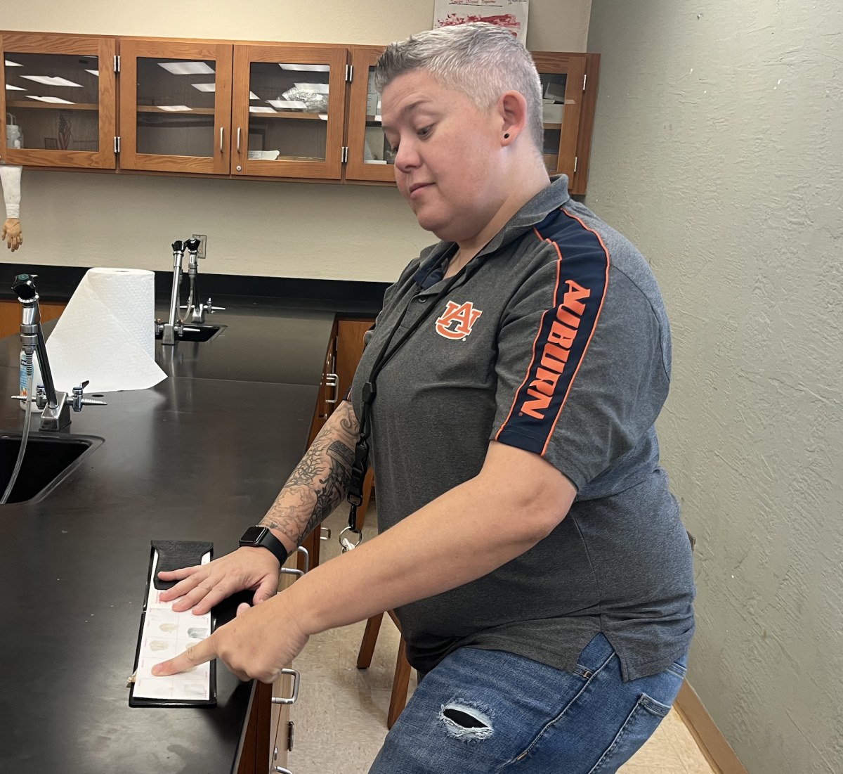 Ms. Rew in her classroom performing a fingerprint identification.